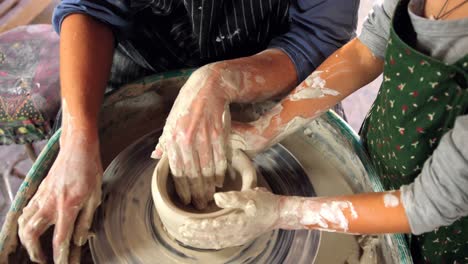 female potter assisting a girl