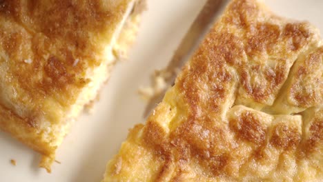 close-up of a golden omelet being cut
