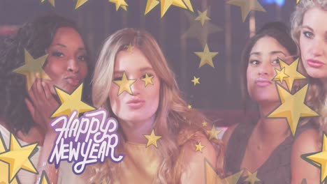 animación de texto de feliz año nuevo y estrellas doradas sobre un grupo diverso de mujeres felices soplando besos