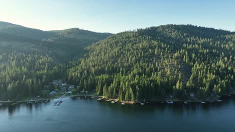 Toma-De-Drone-De-Spirit-Lake,-Idaho,-Con-El-Sol-Besando-Las-Copas-De-Los-árboles.