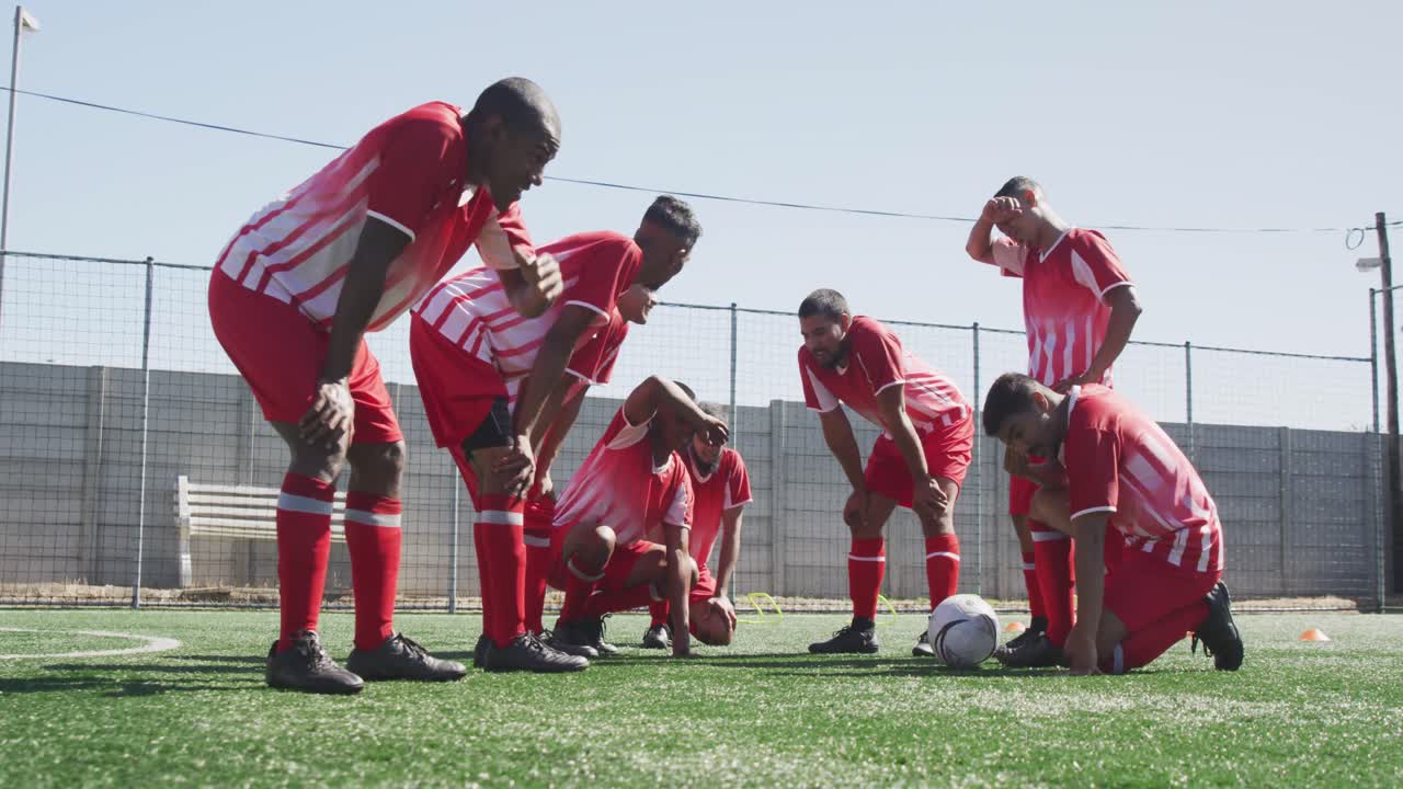 jugadores de fútbol cansados después de entrenar en el campo