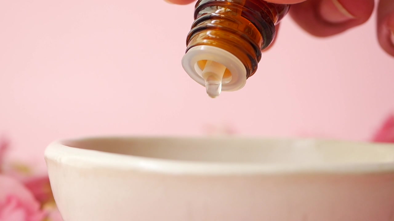 Olio essenziale che gocciola in una piccola ciotola di ceramica