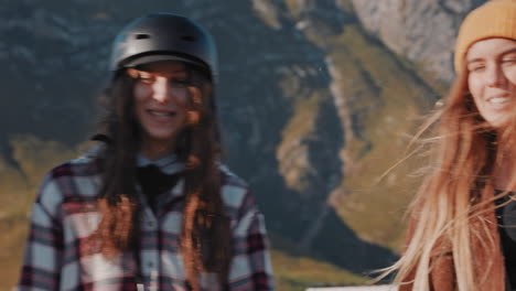 diversos amigos patinadores segurando longboards saindo juntos desfrutando de férias de verão longboarding andando na estrada do campo tendo conversa ao pôr do sol