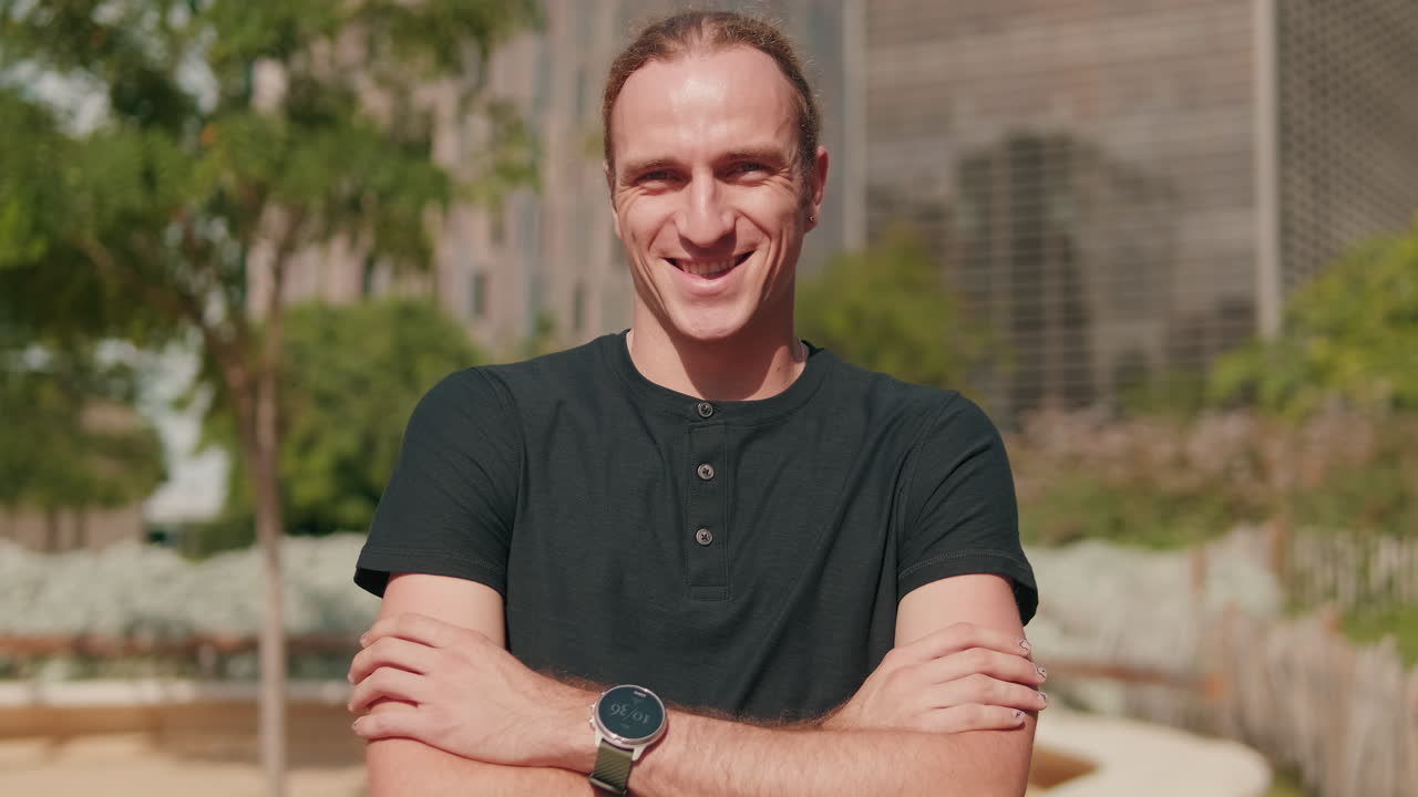 Portrait of handsome European boy with his arms crossed, male student outdoors