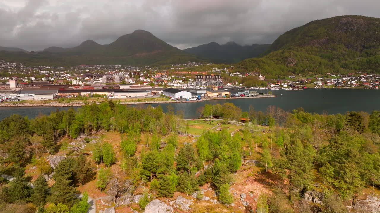 Jorpeland city drone crane over green island. Industrial and commercial area on coast, mountains