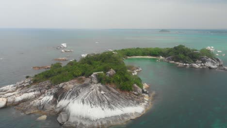 volando hacia atrás en una pequeña isla tropical cerca de belitung indonesia, aérea