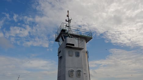 boat tower against blue sky with birds in the ocean