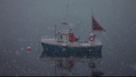 still shot of a small boat during a snow storm in the middle of the ocean, anchored ship waiting for the storm to pass