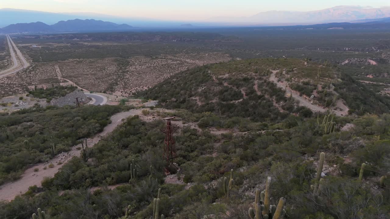 Aerial shot of Cable Carril mining structures winding through the landscape and vegetation near Chilecito, La Rioja, Argentina