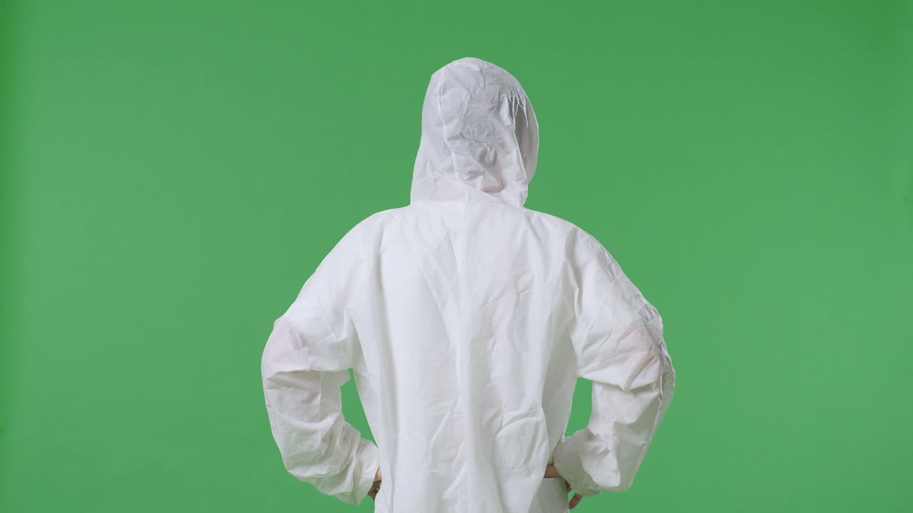 아시아 남성 과학자가 허지에 손을 고 초록색 스크린 배경에서 주위를 둘러보고 있는 모습