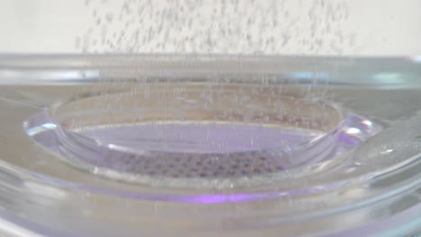 hydrogen gas h2 is raising from mesh grid during electrolysis process - closeup with bubbles raising up through fresh water