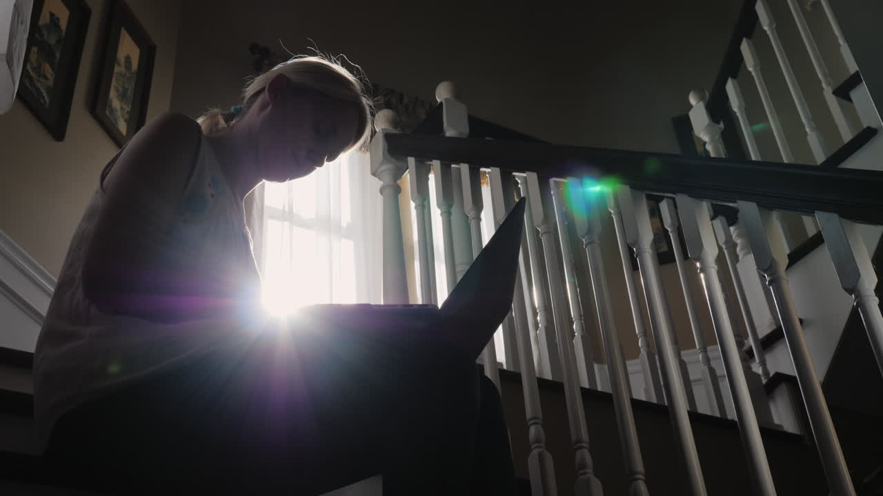 햇볕에 쬐인 여자는 계단에서 태블릿을 사용