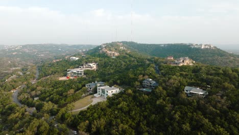 Suburban-Neighborhood-Homes-in-Westlake,-Austin-Texas-overlooking-Lake-Austin-Aerial-pan-right-and-tilt-down-at-sunrise-in-4k