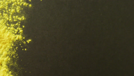 video of yellow powder with copy space on black background