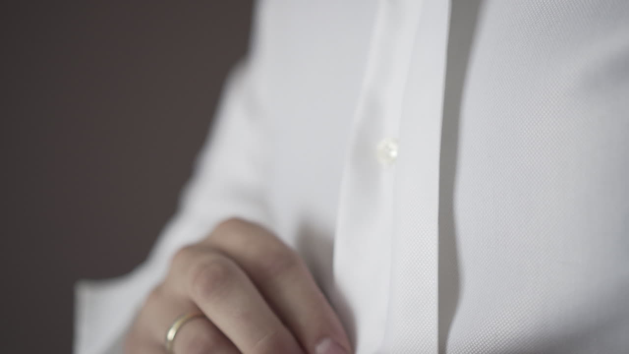 un hombre que se desabrocha los botones de su traje