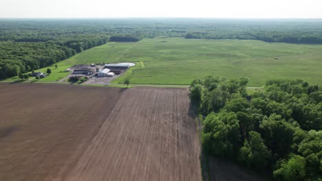 Vista-Aérea-De-Las-Tierras-De-Cultivo-Del-Paisaje-Rural-Con-Molino-En-Un-Día-Soleado