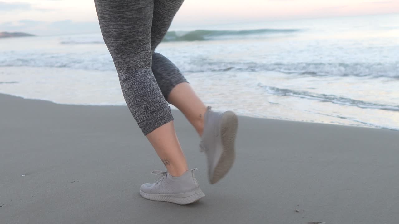 woman's feet running along the beach shore