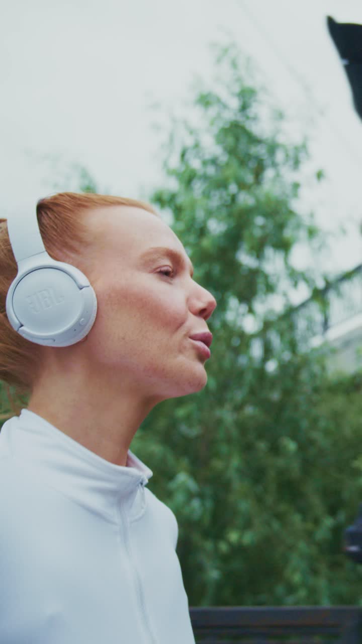 Captivating Moments of a Determined Athlete Enjoying Music with Stylish Headphones Amidst Nature and Urban Energy in a Vibrant Outdoor Setting