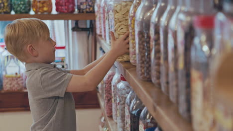 boy looking at candy jars in a shop