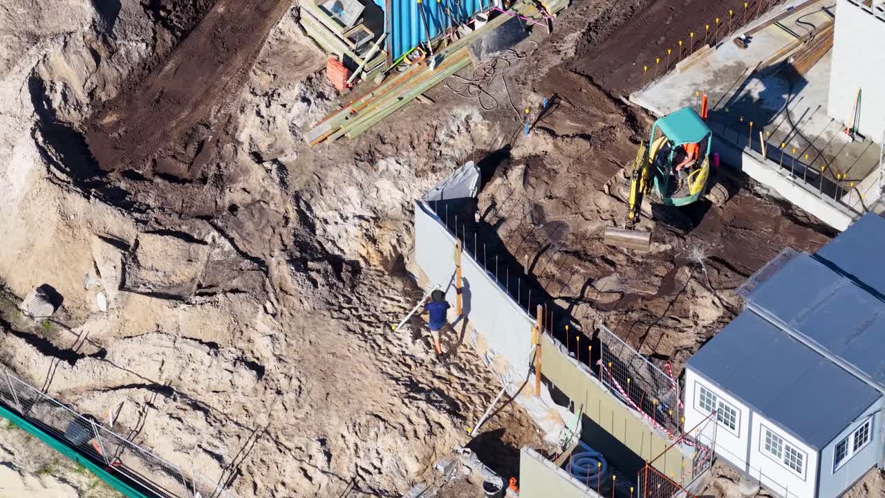 Drone captures workers and machinery at a construction site in Gold Coast, Australia, under bright daylight