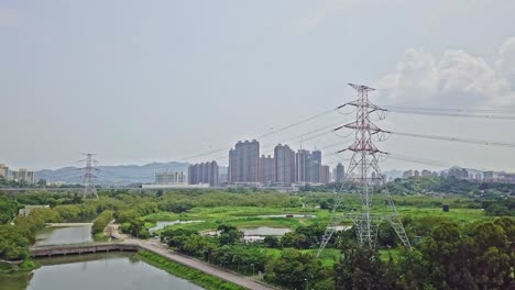 A-dynamic-aerial-shot-of-high-voltage-electric-towers-along-the-town-of-Yuen-Long-in-Hong-Kong