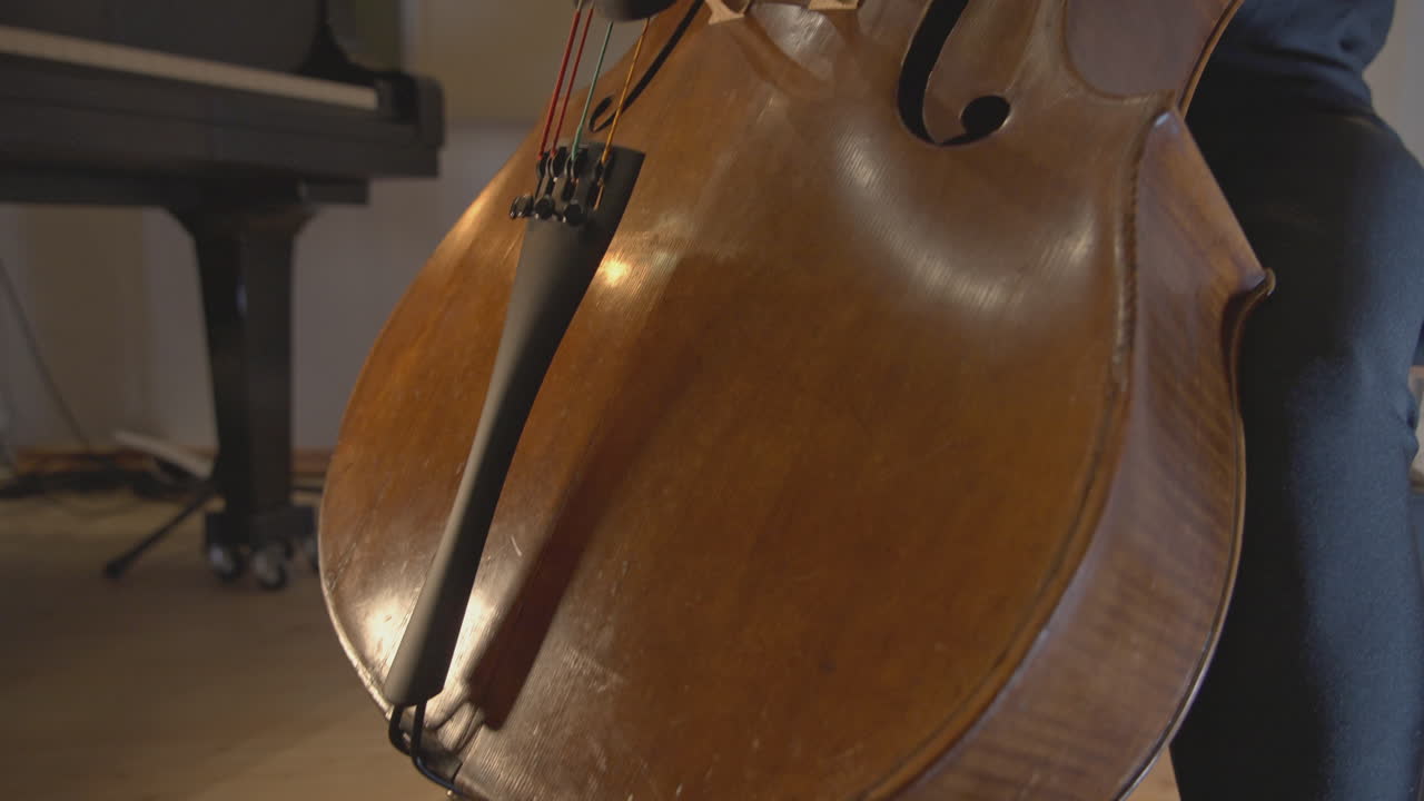 Primo piano di un musicista che suona il violoncello con un archetto