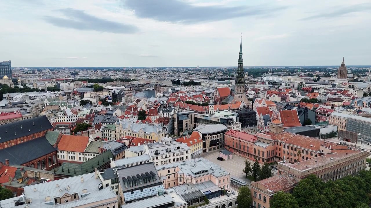 I tetti storici di Vecrīga e l'alta guglia della Chiesa di San Pietro dominano lo skyline della Città Vecchia di Riga in un'ampia ripresa diurna con drone