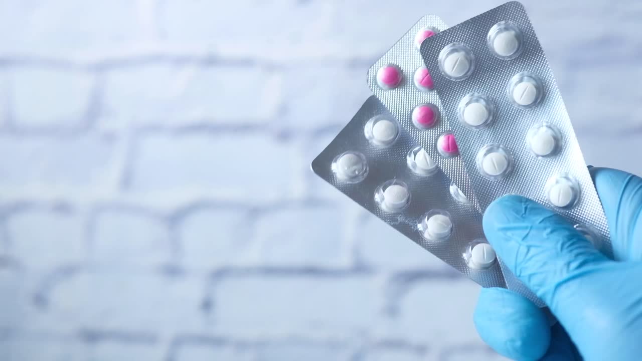 en paquetes de pastillas en blister con guantes de mano