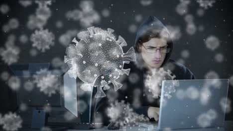 Animation of of macro covid19 cells over man wearing hoodie, using a laptop