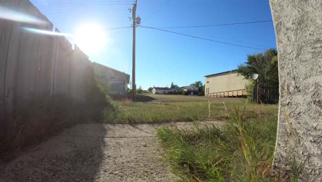 Timelapse---Sunny-windy-day-with-a-view-of-grass-and-buildings-from-a-yard-of-a-house