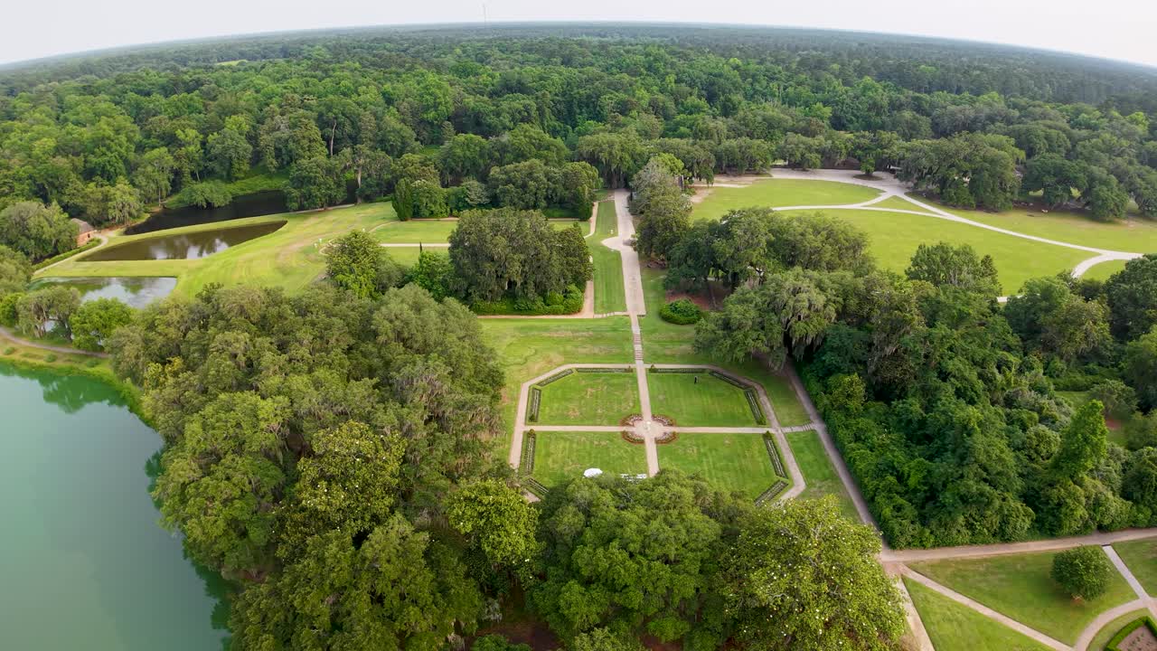 Des vidéos aériennes prises par drone survolent les jardins géométriques et les bassins réfléchissants de la plantation Middleton Place à Charleston, en Caroline du Sud, montrant des chemins qui se croisent, des pelouses verdoyantes et les arbres environnants.