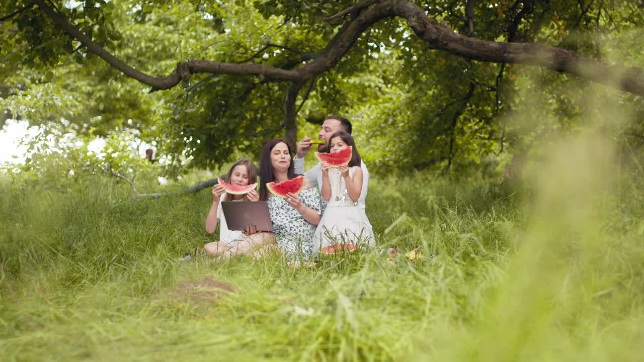 семейный пикник в парке с арбузом