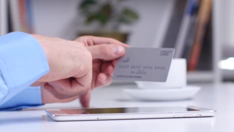 persona que utiliza una tableta para el pago en línea con tarjeta de crédito