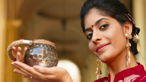 close-up of indian woman carrying a candle lantern outdoors