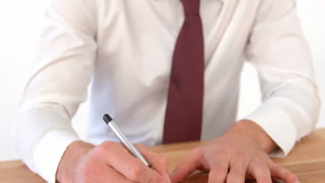 businessman sitting at desk filling mortgage contract form