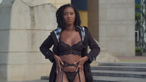 young african girl in a black lingerie outfit walking outdoors in the city of port of spain, trinidad