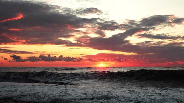 Sun Is Shining Over Horizon At Sunset Sundown. Sea Ocean Waves In Colorful Sunset Sunrise Sky Lights At Summer Evening. Natural Sky Warm Colors