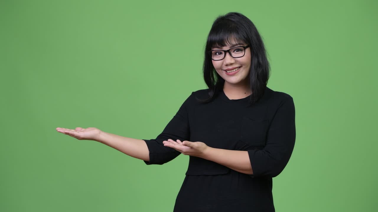 Beautiful Asian businesswoman showing something