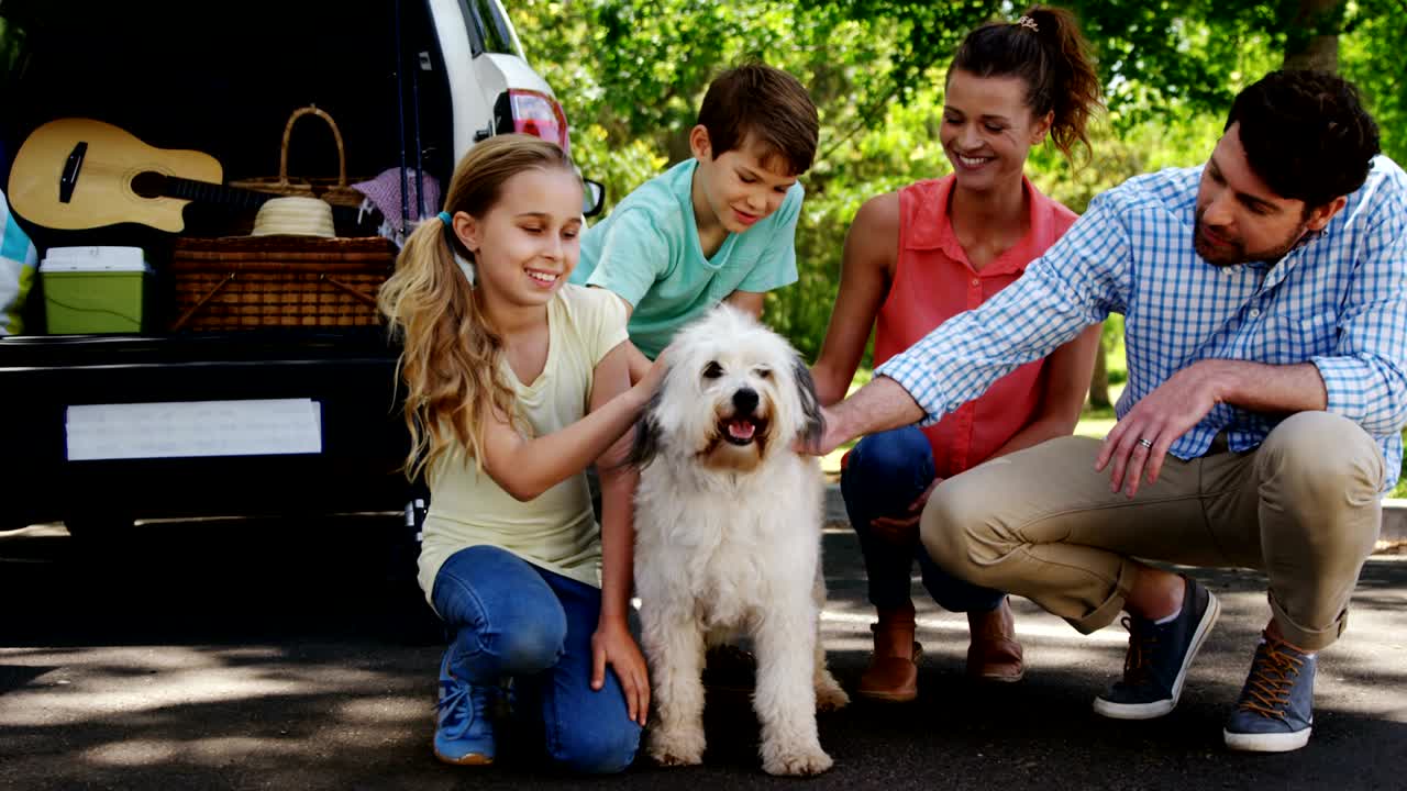 공원에서 개와 함께 앉아 있는 가족