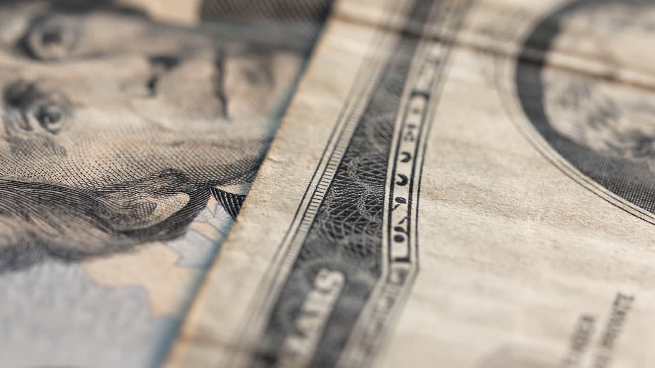 Macro static shot of various US dollar banknotes falling into frame