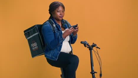 Woman-Using-Phone-And-Bicycle-For-Job