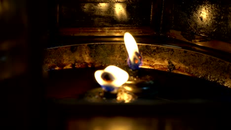 the flame of the candle in the oil lamp