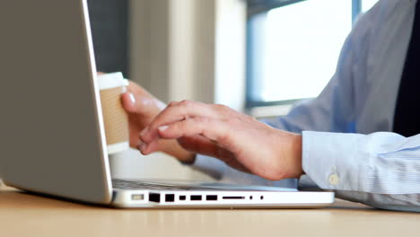 hombre de negocios usando una computadora portátil y bebiendo café