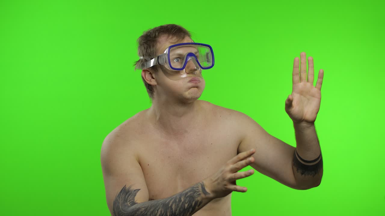 Uomo turista emotivo a torso nudo con maschera subacquea su sfondo chroma key