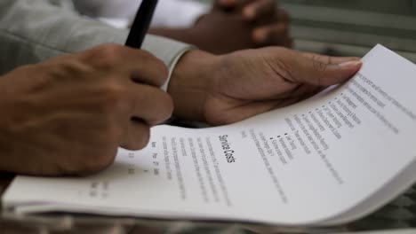 cropped shot of male hands signing documents