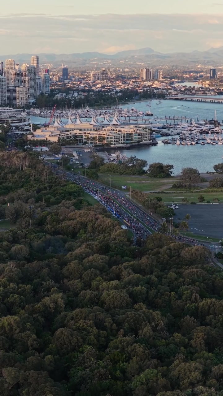 Riprese aeree verticali con movimento laterale a destra e panoramica a sinistra sopra il percorso della Maratona della Gold Coast, vicino a Southport e Surfers Paradise, Queensland, Australia