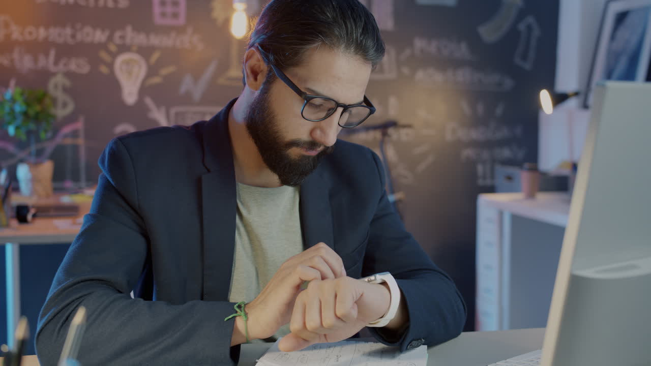Businessman Checking Wristwatch in Modern Office