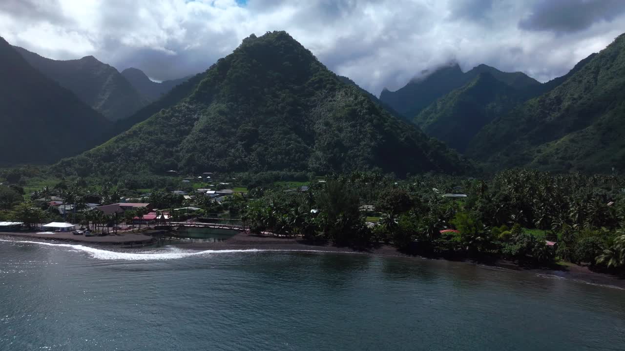 teahupoo tahiti nuevo puente peatonal vista aérea de drones costa de la bahía de la polinesia francesa nubes del cielo azul wsl surfing lugar olímpico de verano ciudad pueblo picos de montaña surfista onda arrecife movimiento hacia adelante