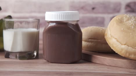 chocolate, leche y pan en una mesa de madera