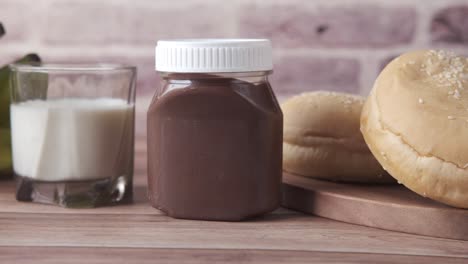 chocolate spread, milk, and bread on wooden table